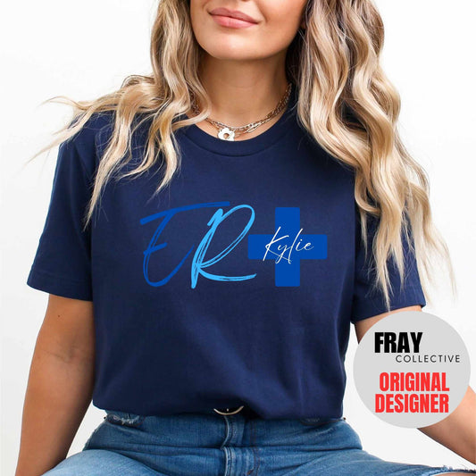 Personalized ER nurse/tech shirt—navy tee with modern ER lettering and blue cross showing custom name and credentials; great for emergency department teams.